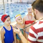 SSV Bingen - Schwimmerinnen lauschen den Anweisungen des Trainers am Beckenrand